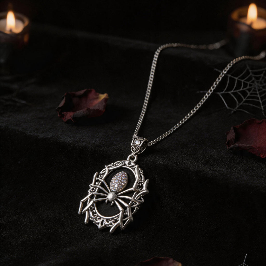 Silver-tone spider cameo necklace displayed on dark fabric