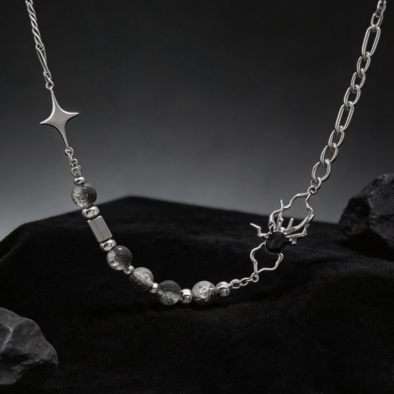 Spider necklace with mixed chain links and star detail against a dark background