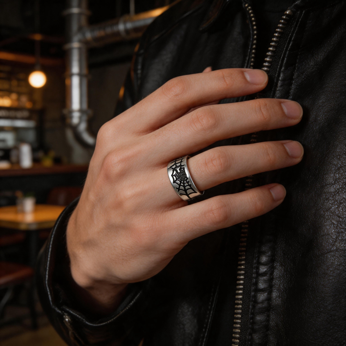 Silver-tone spiderweb band ring on a white background